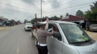 Personel Polres Kutai Barat membagikan masker kepada masyarakat sebagai upaya melindungi warga dari dampak asap sekaligus mengimbau masyarakat meningkatkan kewaspadaan terhadap kebakaran hutan dan lahan (Karhutla).