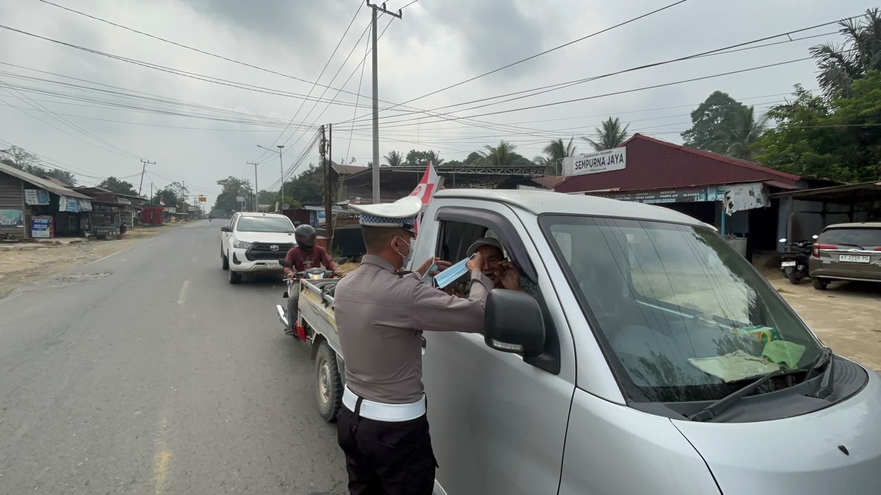 Personel Polres Kutai Barat membagikan masker kepada masyarakat sebagai upaya melindungi warga dari dampak asap sekaligus mengimbau masyarakat meningkatkan kewaspadaan terhadap kebakaran hutan dan lahan (Karhutla).